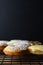 Decorated Mini Doughnut Cakes on Cooling Rack with Black Background