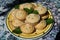 A decorated plate of lemon muffins with mint ready to eat