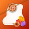 Decorated rakhi with gift box and shopping bag on shiny orange b
