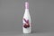 Decorated wedding bottle of champagne on gray backdrop.