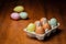 Decorated yellow, green and brown hen eggs in cardboard box