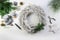 Decorating an advent wreath from white wood with green fire branches, pale golden Christmas balls and gray candles for a natural