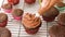 Decorating chocolate cupcakes with chocolate buttercream frosting using a pastry bag