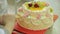 Decorating cream cake with swirls using piping bag.