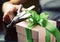 Decorating gift box with green ribbon using scissor