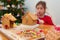 Decorating home baked gingerbread houses with colorful sweet pastilles and sparkling glitter