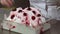 Decorating ice cream by cherry berries and filling with red topping