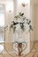 Decoration of artificial flowers in a vase in a ceremonial hall at a wedding ceremony, a close-up detail, a stand or a