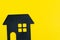 Decoration black house shape on solid yellow background with copy space using as happy home, good living and lifestyle or buy and
