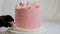 Decoration of a cake for a family christening pink cake with footprints of small child on top of angel wings and baby in