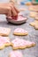 Decoration of christmas cookies with pink royal icing, sugar pearls and frosting