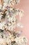 Decoration on Christmas tree - light violet birds and glassy ball on snowy spruce against pink background. Closeup