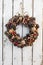 Decoration christmas wreath on white rusty wooden board backround, natural wreath, vertical