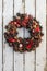 Decoration christmas wreath on white rusty wooden board backround, natural wreath, vertical