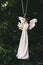 Decoration hanging in a Christmas tree in the shape of an angel with a harp