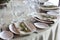 Decoration of leaves lying on a white plate on the table in the restaurant. Wine glasses, forks.