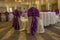 Decoration of tables and chairs in a hotel interior. Whtie and purple or violet textile