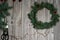 Decoration of a wreath on the door of fir branches and willow twigs. Materials and tools, red bells, scissors and hemp rope on a