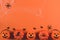 Decorations for Halloween on an orange background, copy space. Pumpkins and spiders in a web on an orange background, top view