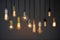 Decorative antique Edison style light bulbs, different shapes of retro lamps on dark background. Cafe or restaurant decoration