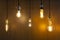 Decorative antique edison style light bulbs on wooden wall background