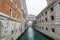 Decorative archway over a canal connecting two buildings.