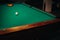 Decorative billiard hole and green table with balls in the billiard club