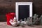 Decorative bird, empty blackboard, candle in lantern and branches fur tree on aged wooden background.