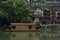 A decorative boat awaits tourists to board for a sightseeing tour along the Tuo Jiang River of Fenghuang Ancient City in Tibet,