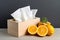 Decorative box of tissues and fresh oranges on a rustic table