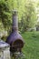 Decorative bronze wooden stove in a garden, barbecue with grill .
