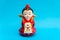 Decorative ceramic Korean figure, female in traditional colorful clothes Han bock over a turquoise background.