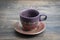 Decorative ceramic painted cup and saucer on wooden background, close up