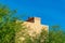 Decorative chimney with light adobe beige cement and orange tiles with front or back yard trees and plants