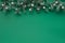 Decorative Christmas border on green textile tablecloth, text space. Fir twigs decorated with Xmas baubles, mirror disco balls,