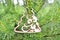Decorative christmas decoration christmas tree figurine carved from wood hanging on natural branches of christmas tree.