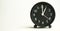 Decorative close-up black analog alarm clock for 13 o`clock separating white background with copy space