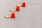 Decorative clothespins with red hearts for Valentine`s Day on a gray glittering background