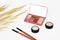 Decorative cosmetics, eye shadow, makeup brushes and a bouquet of dry grass