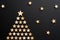 Decorative craft stars form a christmas tree against black background