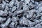 Decorative dark pebbles, like coal, close-up, background, texture. For modern abstract pattern, wallpaper or banner