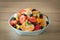 Decorative deep plate full of pieces of different types of fruit. Healthy and refreshing salad