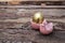 Decorative dyed golden easter eggs in pink glossy ceramic decoration with hen on dark brown wooden background with copy space.