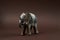Decorative elephant toy on brown background with copy space