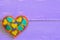 Decorative felt heart for Valentines Day. Embroidered heart ornament isolated on purple wooden background with copy space for text