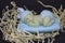 decorative figure of a sleeping baby on a blue pillow in straw