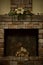 Decorative fireplace with birch logs, with a chimney fragment and composition of artificial flowers decorating