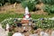 Decorative garden gnomes in various shapes and sizes surrounded with solar lights rocks and small flowers in local garden