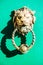 Decorative gilded lion head door knocker on green door Bruges