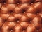 Decorative ginger background of genuine leather. Decorative brown background of genuine leather capitone texture